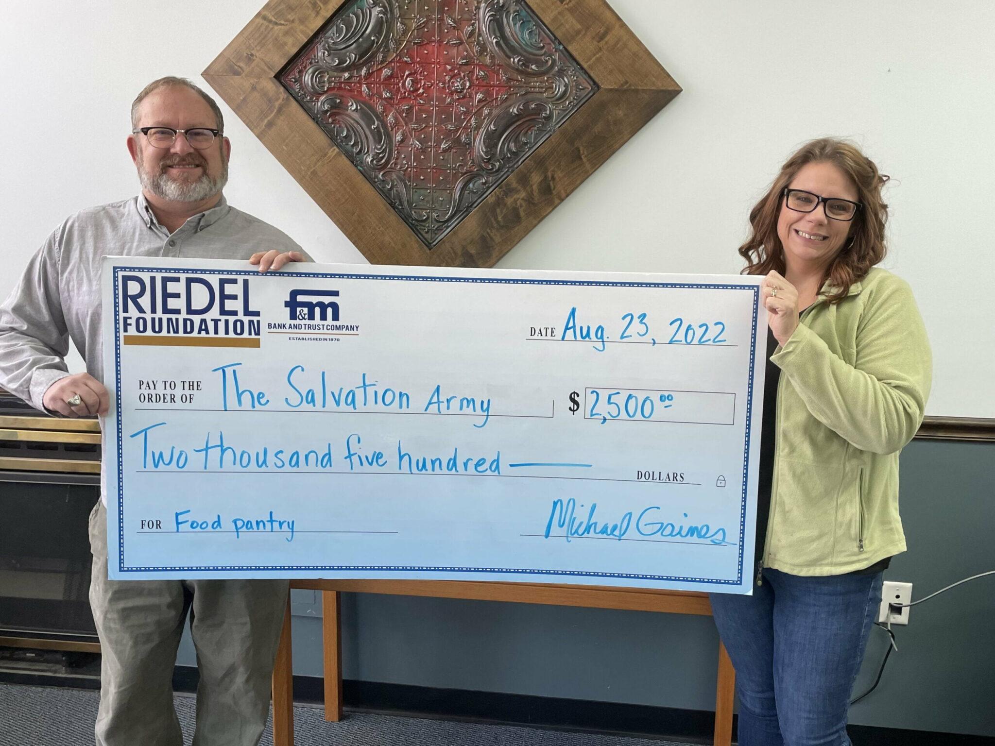 Riedel Trustee Michael Gaines presents a $2,500 check to Amanda Bowen, Family Caseworker with The Salvation Army of Hannibal.