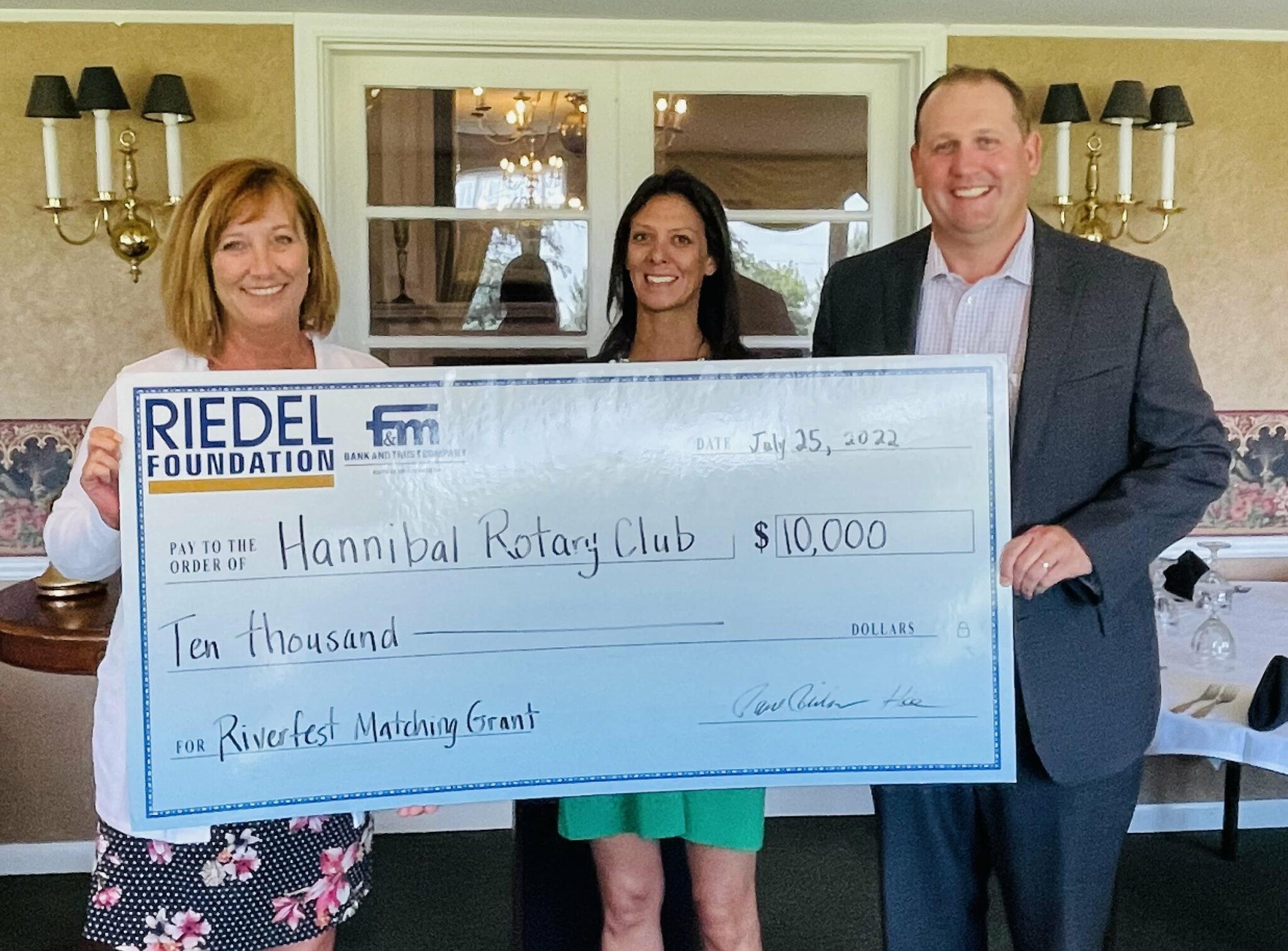 Riedel Administrator Sarah Deien presents a check to the Hannibal Rotary Club to establish the Good Dads program.