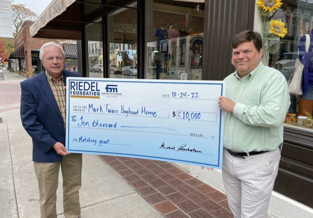 Riedel Foundation Trustee Bill Craigmiles presents a check to James Lundgren with the Mark Twain Boyhood Home Foundation.