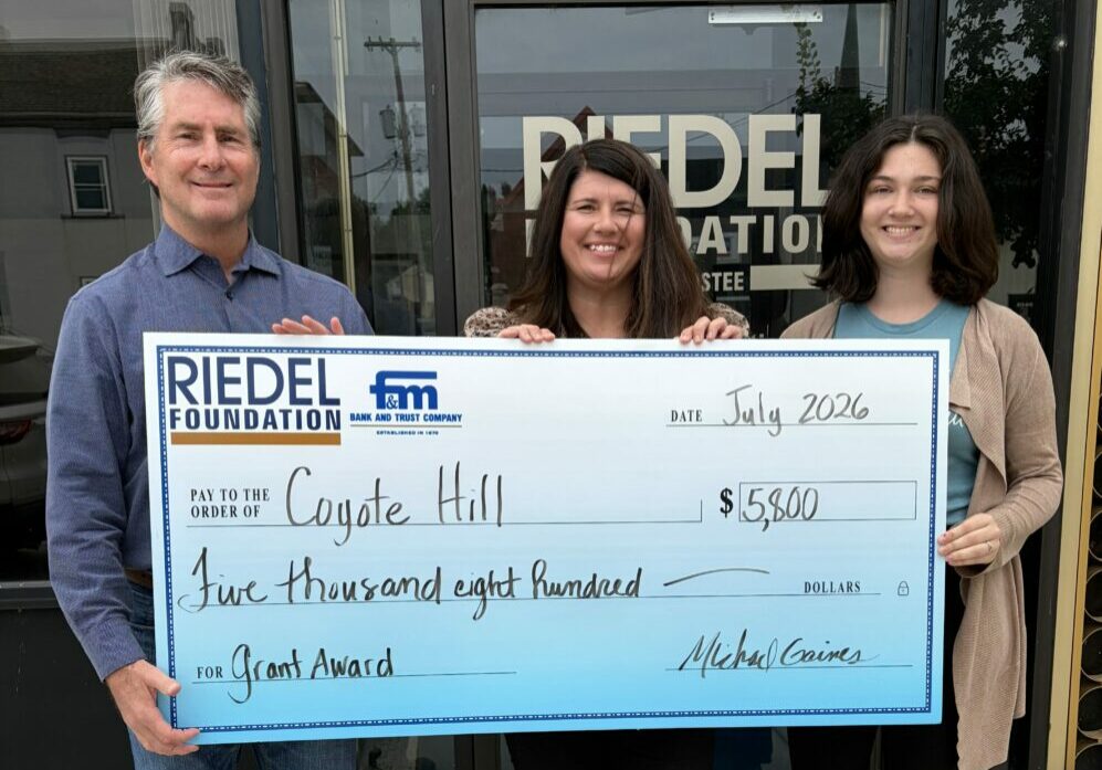 Riedel Foundation Trustee Paul Richards presents a grant award to Mandy McFarland and Amanda Kohl, Family Advocates for Coyote Hill Foster Care Ministries.