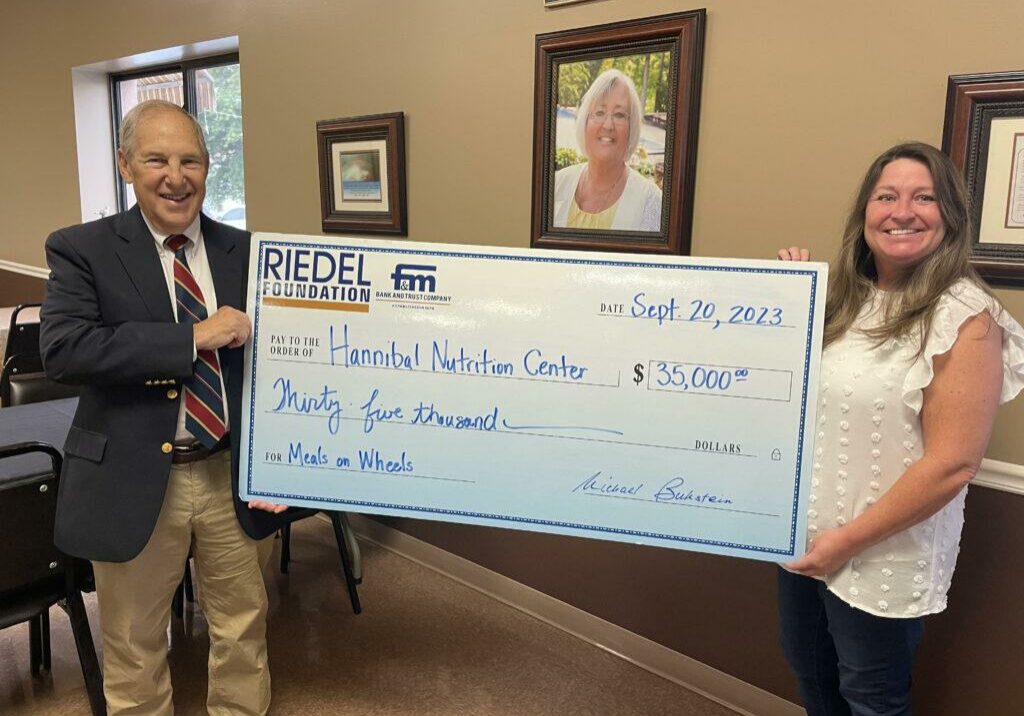 Riedel Foundation Trustee Michael Bukstein presents a $35,000 matching grant to Hannibal Nutrition Center Administrator Margee Tucker.