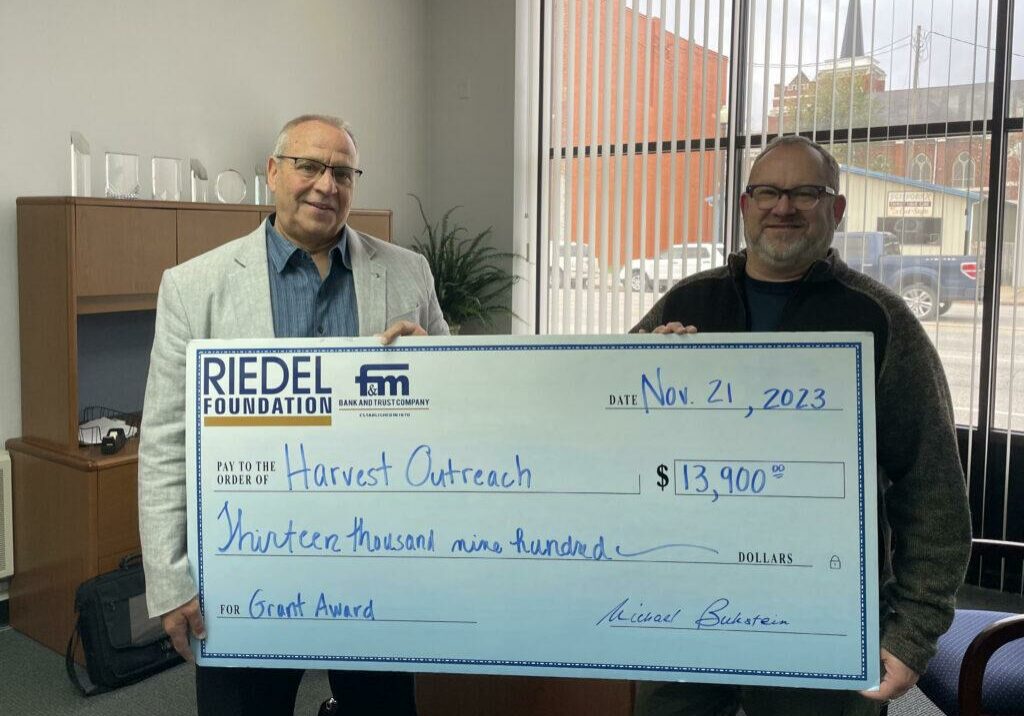 Riedel Trustee Michael Gaines presents a grant award to Pastor Larry Hinds of Harvest Outreach Ministries.