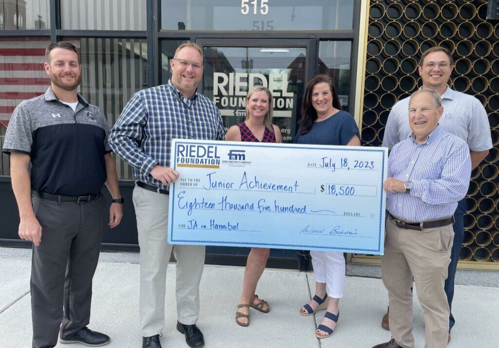 Riedel Foundation Trustee Dr. Michael Bukstein presents a check to fund Junior Achievement in Hannibal.  Pictured left to right:  Hannibal Public Schools Chief Operating Officer Ted Sampson, Junior Achievement Board Member J.R. Bareis, HPS Assistant Superintendent Meghan Karr, HPS Superintendent Susan Johnson, JA Director Taylor Rakers, Riedel Foundation Trustee Dr. Michael Bukstein.