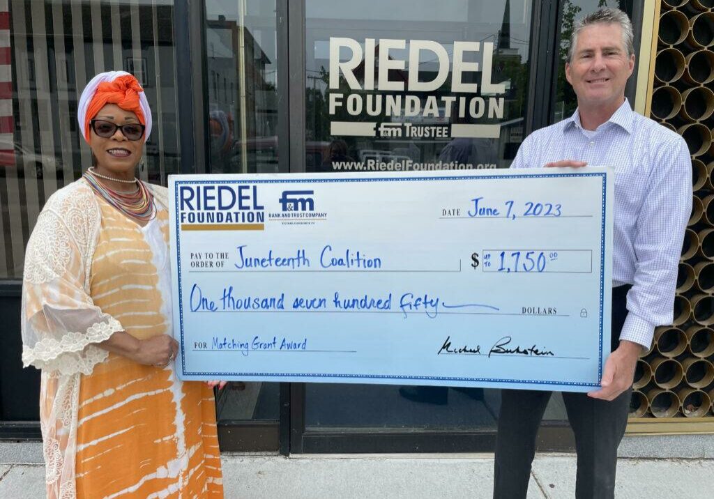 Riedel Trustee Paul Richards presents a check representing the $1,750 grant the Hannibal Juneteenth Coalition will receive after successfully raising the matching amount.