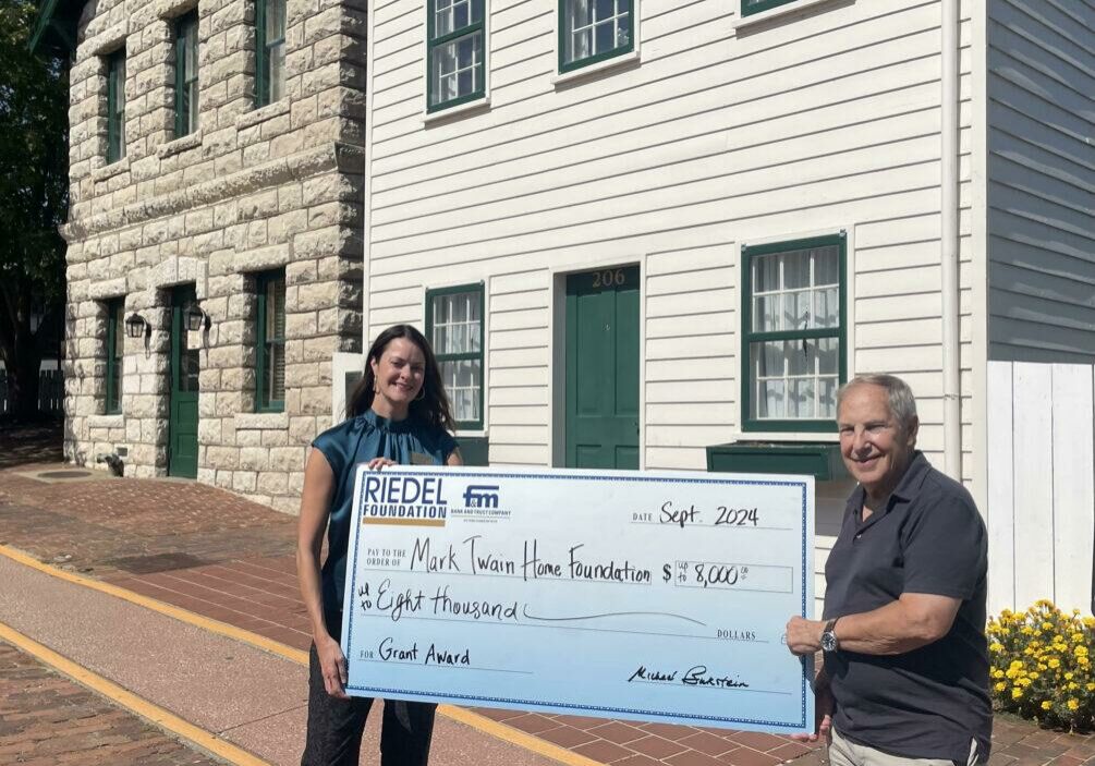 Museum Director Megan Rapp accepts an $8,000 grant from Riedel Foundation Trustee Michael Bukstein.