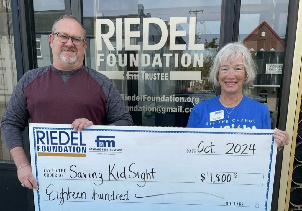 Riedel Trustee Michael Gaines presents a grant award to Mary Jane Noellsch with Saving KidSight.