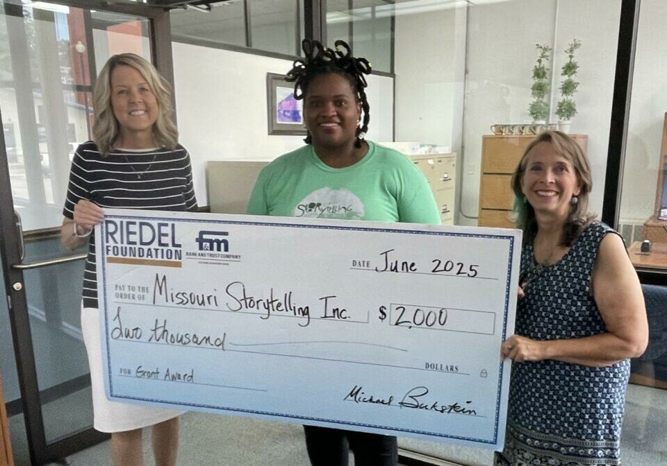 Riedel Trustee April Baldwin presents a grant award to Master Storytellers Angela Williams and Gale Rublee.
