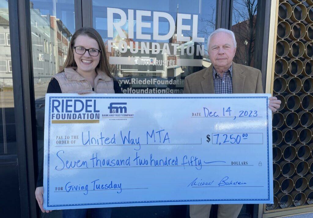 United Way Director Denise Damron accepts a grant award from Riedel Trustee Bill Craigmiles.