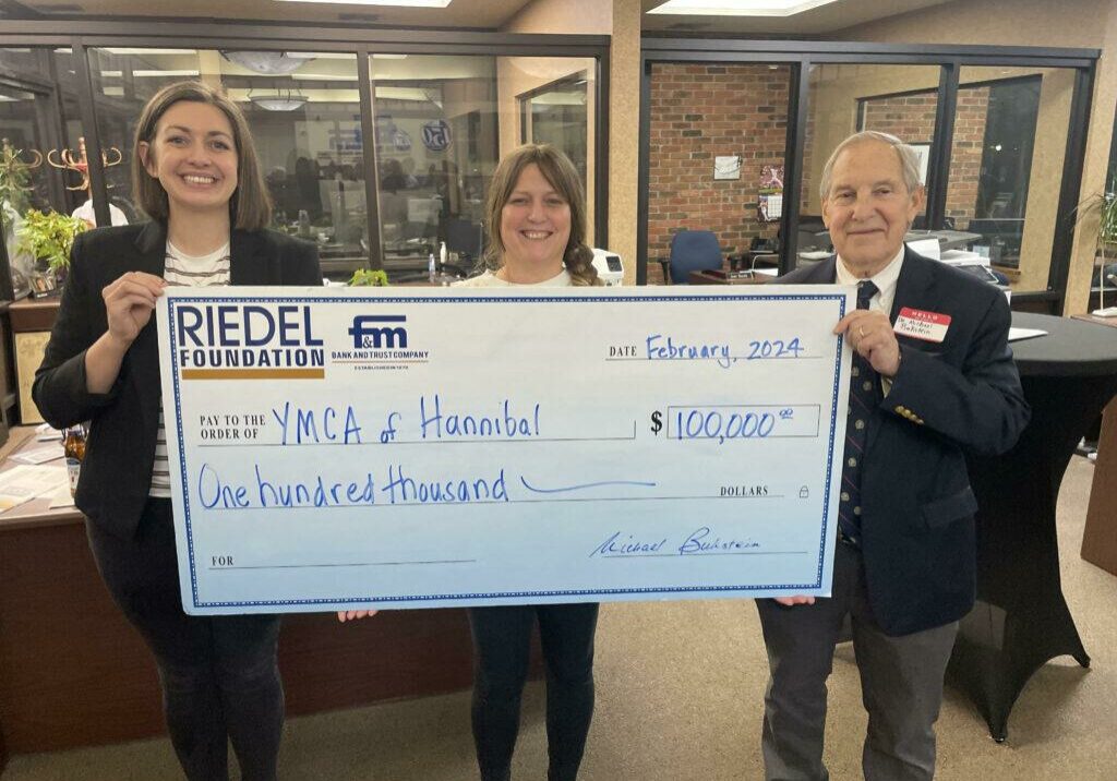 Riedel Foundation Lead Trustee Michael Bukstein presents a grant award to Crystal Freeman and Becca Immegart with the YMCA of Hannibal.