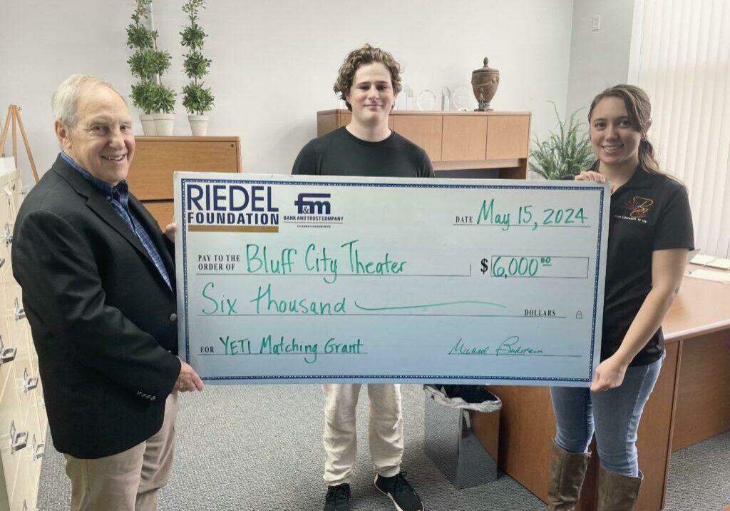 Riedel Foundation Lead Trustee Michael Bukstein presents a $6,000 matching grant award to YETI Youth Coordinator Roland Meisler and Bluff City Theater Artistic Director Jayme Brown. The grant will fund summer youth theater camps in Hannibal.
