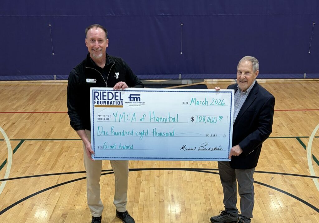 Hannibal YMCA CEO Eric Abts accepts a $108,000 grant from Riedel Foundation Lead Trustee Michael Bukstein.