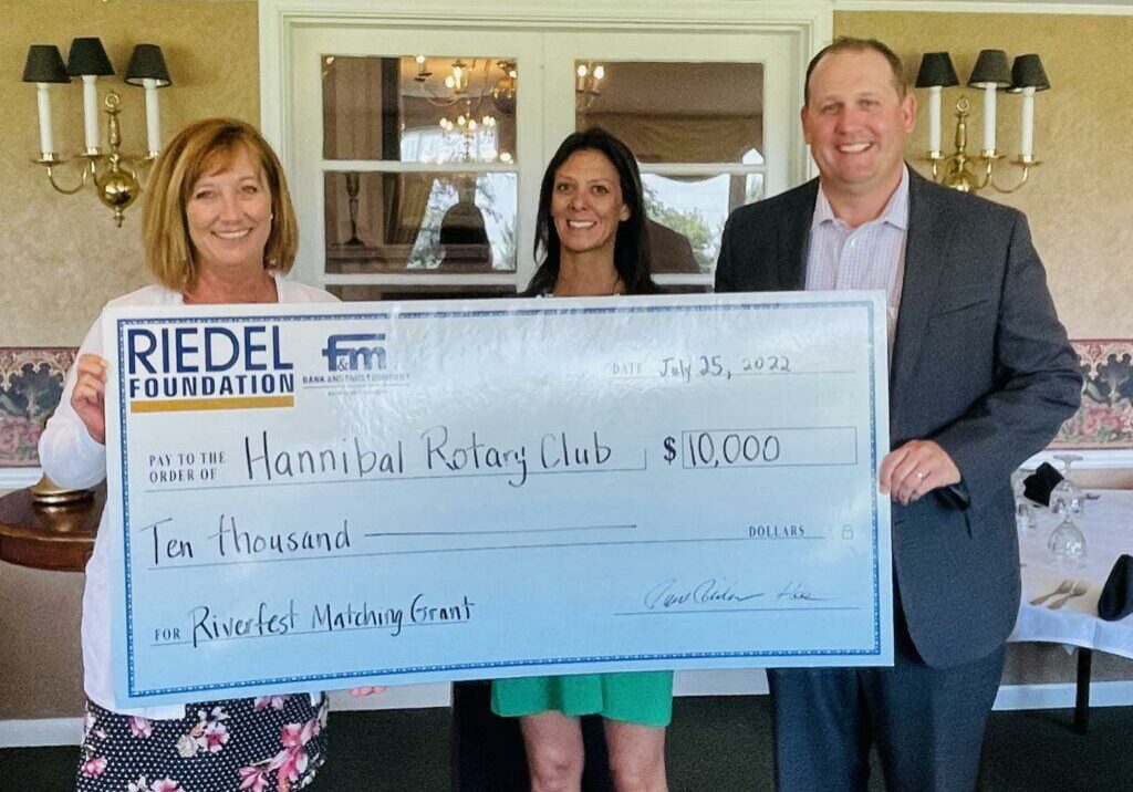 Riedel Administrator Sarah Deien presents a check to the Hannibal Rotary Club to establish the Good Dads program.